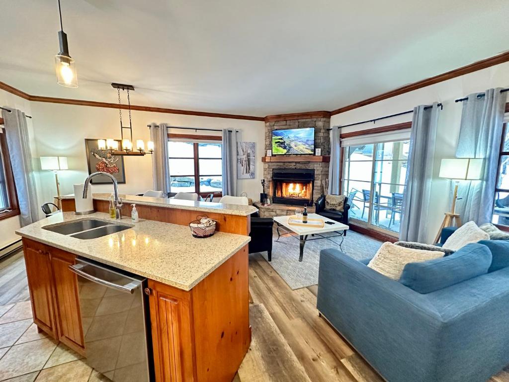 a kitchen and living room with a couch and a table at Le Plateau by Tremblant Vacations in Mont-Tremblant