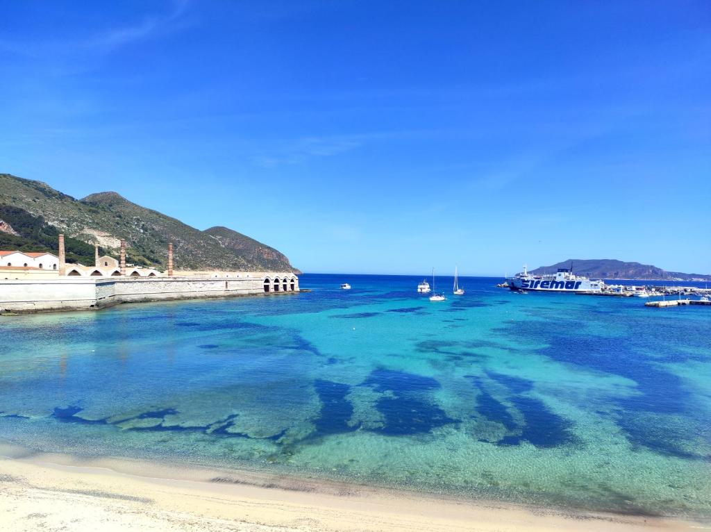 a body of water with a beach and boats in it at Case per Vacanze Praia in Favignana