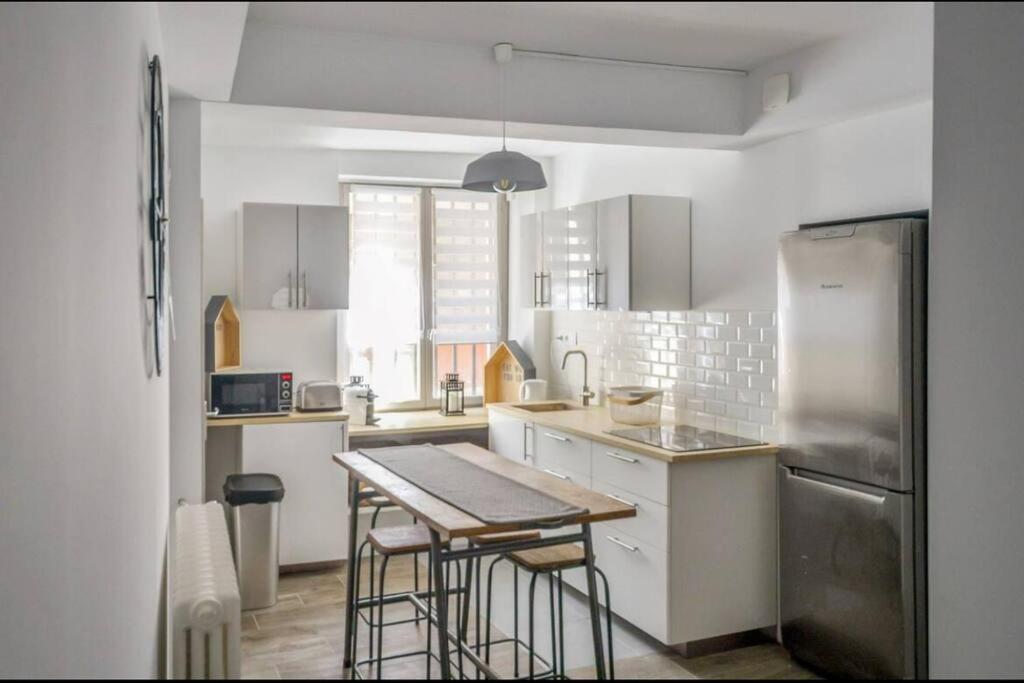 une cuisine avec une table et un réfrigérateur dans l'établissement Au cœur d'AVIGNON 2 - WIFI - CENTRE VILLE, à Avignon