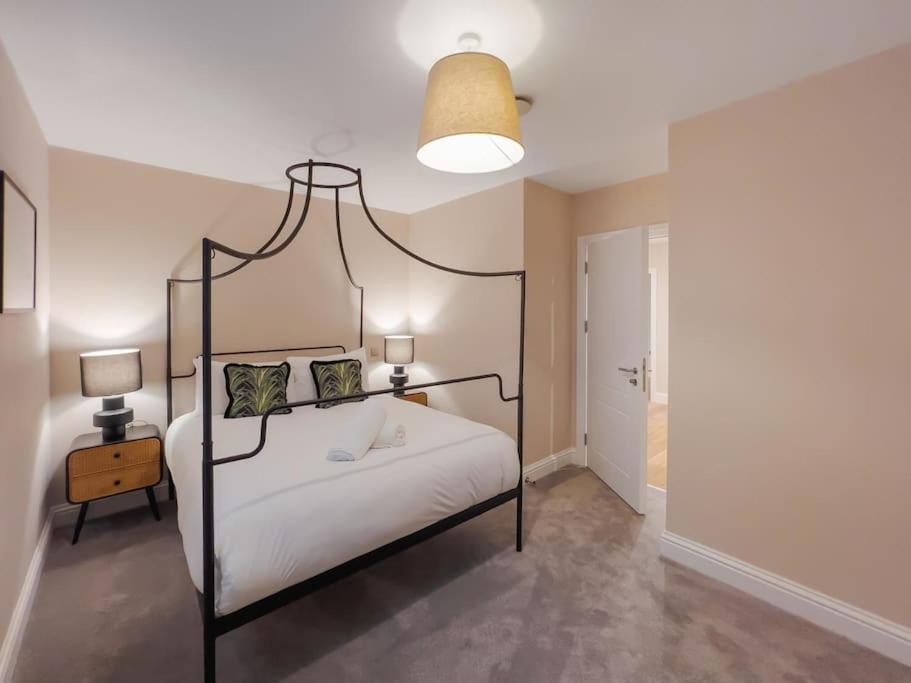 a bedroom with a bed with a black frame and a lamp at Escape in Style to Windsor with Free Parking in Windsor