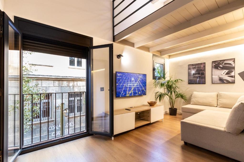 a living room with a couch and a large window at Exclusive Apartments Barcelona 4 personas Vall in Terrassa