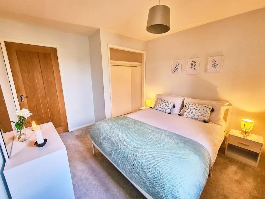 a bedroom with a bed and a table with two lamps at Bluebirds Cottage - Light & Airy 2 Bed in Bourton! in Bourton on the Water