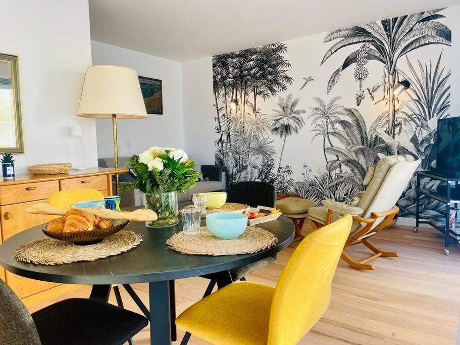 une salle à manger avec une table, des chaises et une table dans l'établissement Vue mer à La Baule : Le Victor Hugo, à La Baule