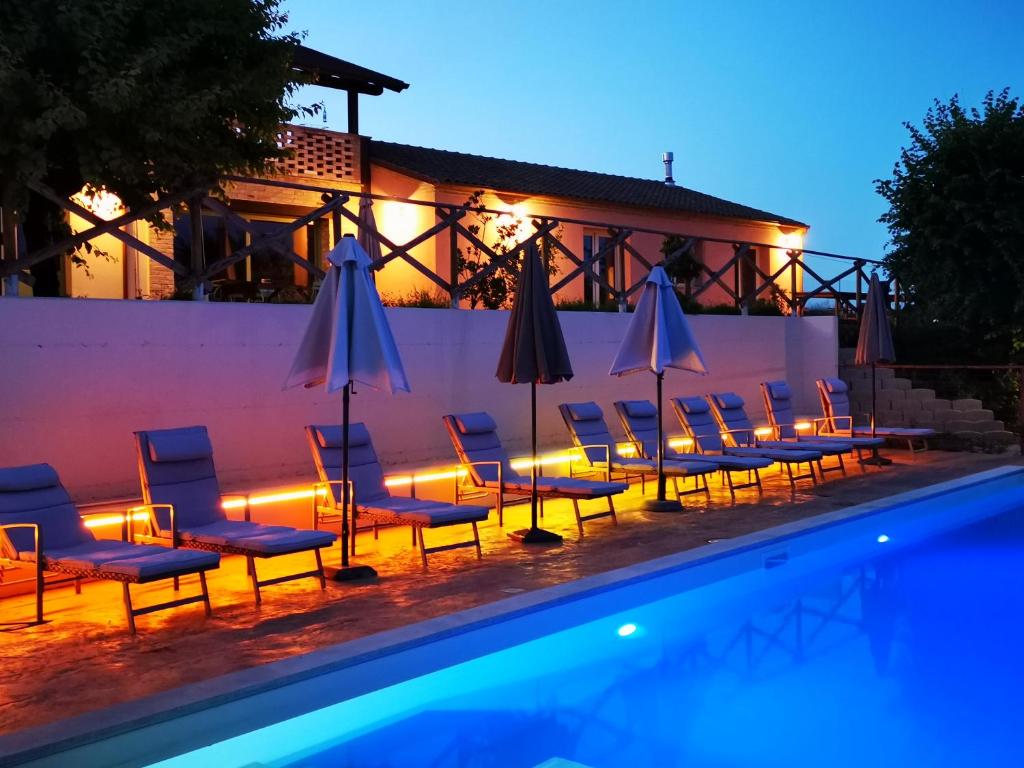 um grupo de cadeiras e guarda-sóis ao lado de uma piscina em Italian Experience- Villa BellaLuce 18 em Loreto