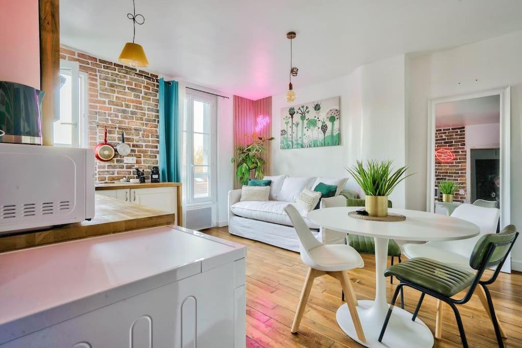 een keuken en een woonkamer met een witte tafel en stoelen bij Fabuleux Paris/ Stade de france in Saint-Denis