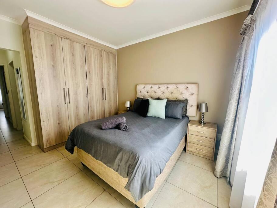 una camera con un grande letto e armadi in legno di House of Orchid a Boskruin