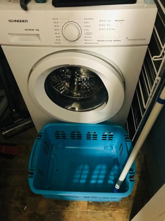 a washing machine with a blue basket next to it at No 25 superbe apartment plein centre calme ,Netflix in Mirepoix