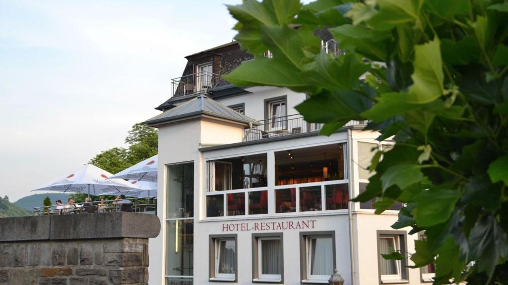 a white building with a restaurant on top of it at Hotel La Baia in Cochem