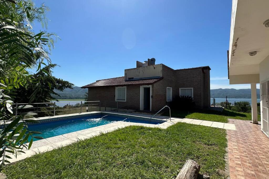une maison avec une piscine en face de celle-ci dans l'établissement Casa vista panorámica al lago, à Córdoba
