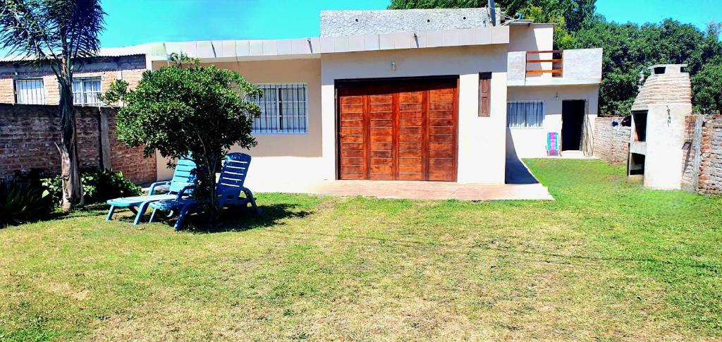 une maison avec deux chaises devant elle dans l'établissement Casa Santa Clara, à Santa Clara del Mar