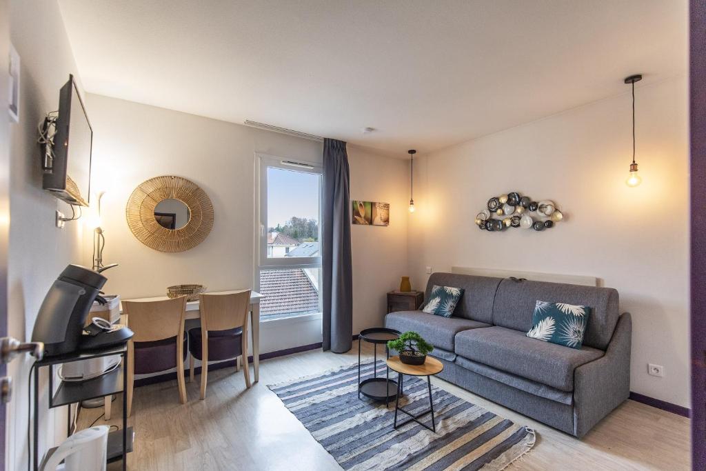 un salon avec un canapé et une table dans l'établissement Tithome 2 - Gare, centre ville, vue montagne et château, à Lourdes