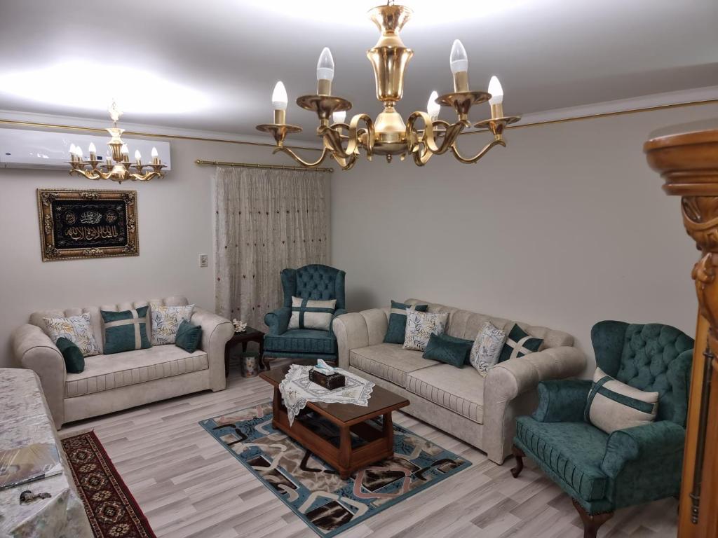 a living room with couches and chairs and a chandelier at TBK1 apartment in Alrehab city for families only in Burg el-Ḥudûd