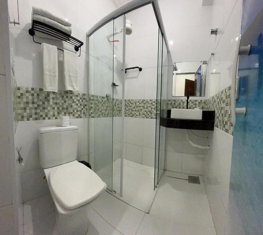 a bathroom with a toilet and a glass shower at Mais Hotel Express in São Luís