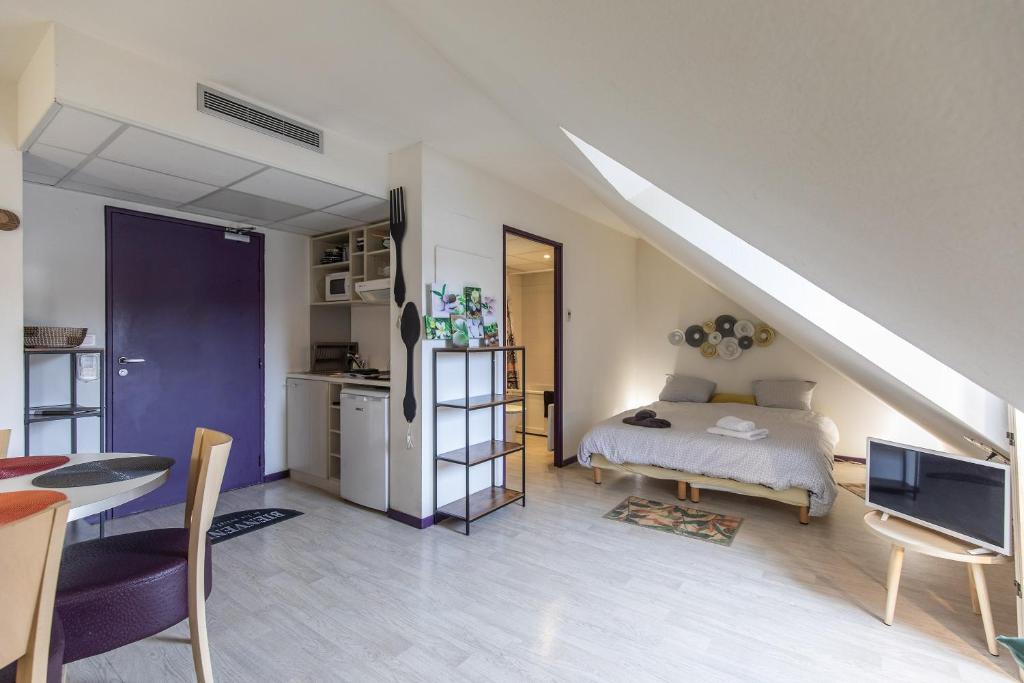 Cet appartement comprend une chambre avec un lit, une cuisine et un escalier. dans l'établissement TITHOME 3 - Grand studio bus gare centre ville sanctuaire, à Lourdes