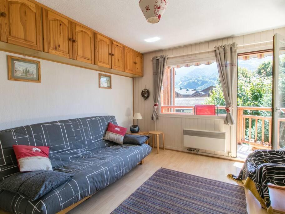 un salon avec un canapé bleu et une fenêtre dans l'établissement Appartement cœur de village, à Samoëns