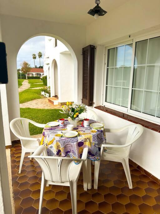 a table with white chairs and a tablecloth on a patio at Appartamento Giuliana in Son Bou