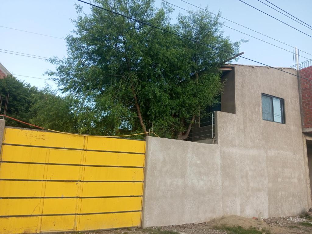 una cerca amarilla frente a una casa en Cómo en casa, en Tarija