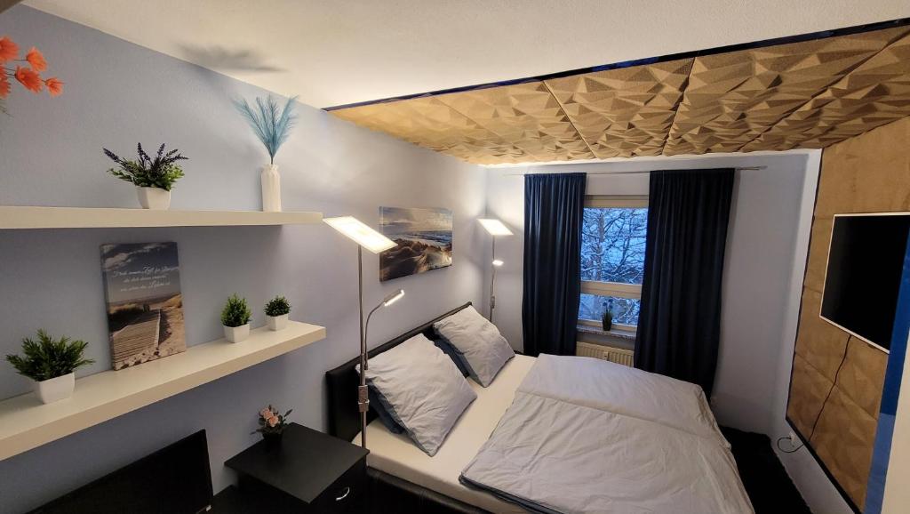 ein kleines Schlafzimmer mit einem Bett und einem Fenster in der Unterkunft Unique Munich Apartment in Unterhaching