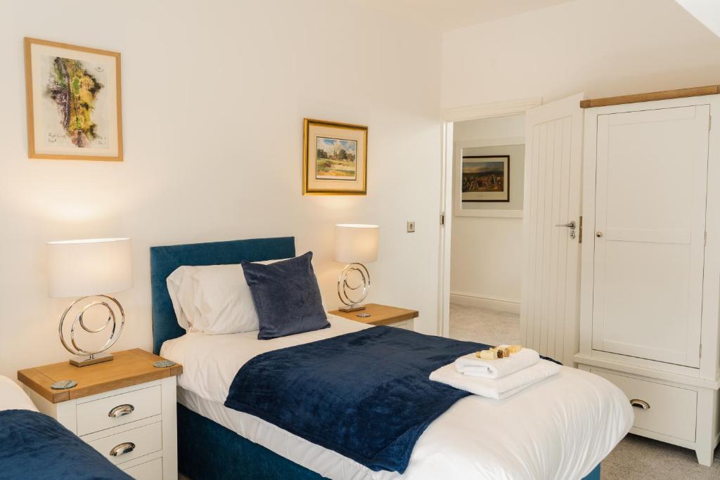 a bedroom with two beds and two lamps at Spacious & modern 2 bed flat in Hoylake - Opposite Royal Liverpool Golf Club in Hoylake