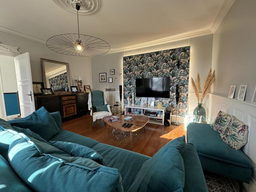 Coulaines的住宿－Havre de Vacances Piscine Reve au Mans，客厅配有蓝色的沙发和桌子