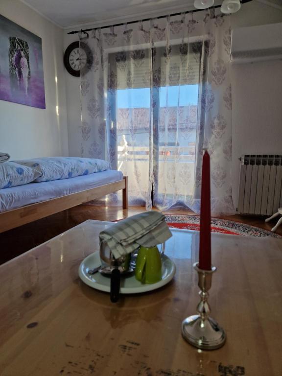 een woonkamer met een kaars en een bord op een tafel bij Stara Ruža in Gračanica