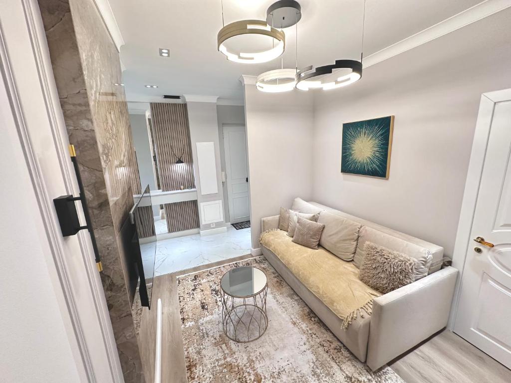 ein Wohnzimmer mit einem Sofa und einem Tisch in der Unterkunft LUXE PALAIS DE LA MÉDITERRANÉE in Nizza