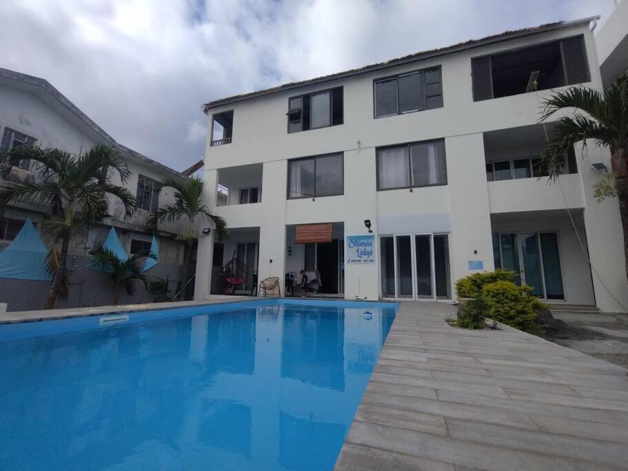 a swimming pool in front of a building at Emira Poolside 3 bedroom family villa in Bain Boeuf