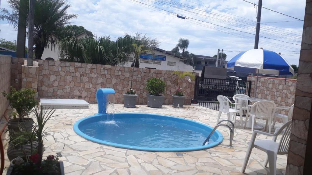 bañera de hidromasaje en un patio con sillas y mesa en Espaço de praia acolhedor para família e pets en Matinhos