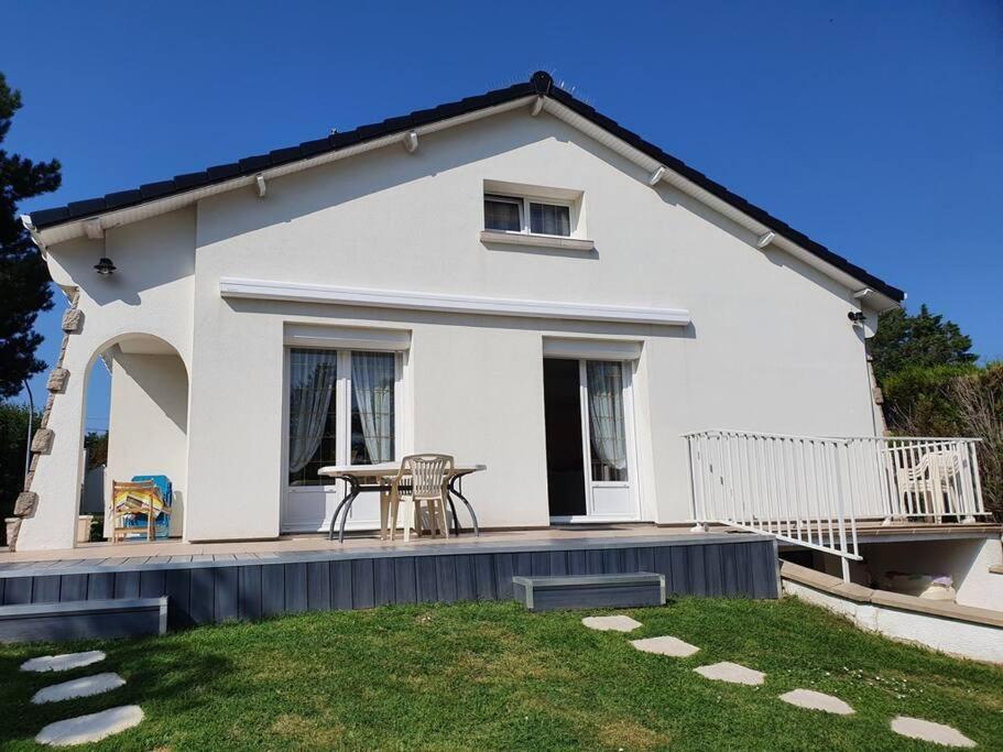 Cette maison blanche dispose d'une terrasse et d'une table. dans l'établissement Maison Sainte Cécile proche plage et commerces, à Camiers