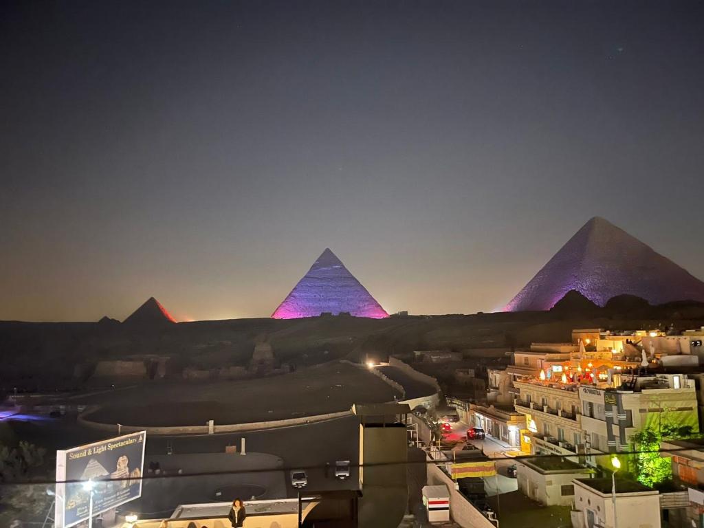einen Blick auf die Pyramiden von Giza in der Nacht in der Unterkunft Happy pyramids view in Kafret el-Gabal