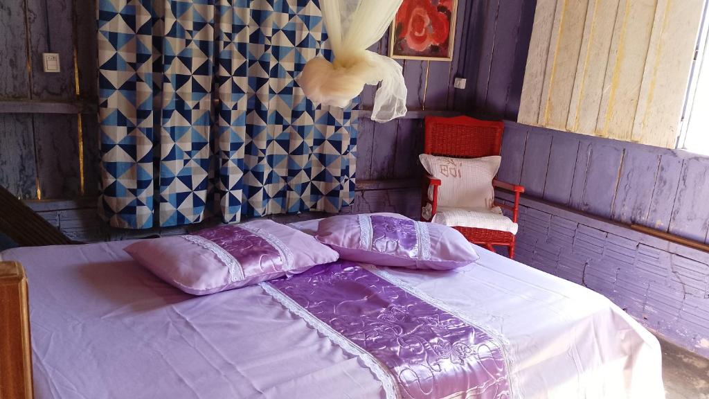 プレジデンテ・フィゲイレドにあるCasa da Prosperidadeのベッドルーム(紫のシーツが敷かれたベッド1台付)