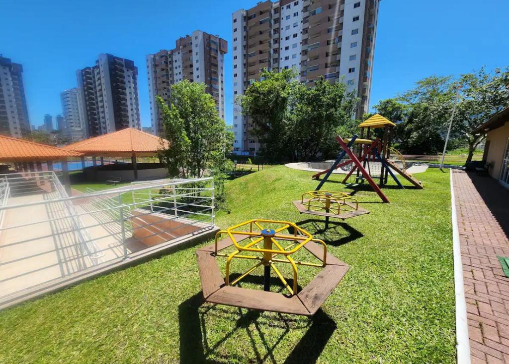 um parque com dois baloiços e um parque infantil em Condomínio Vista Atlântico - Apartamento Novo - Próximo à Praia - Vista Mar - Área de Lazer em Itapema