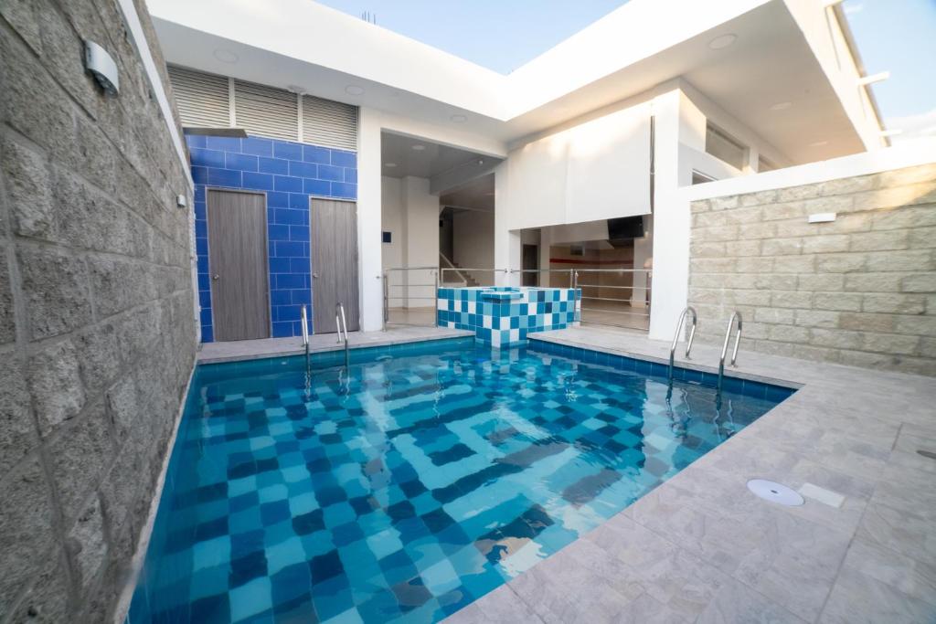 uma piscina com azulejos azuis numa casa em Hotel Santa Marta Tropical em Santa Marta