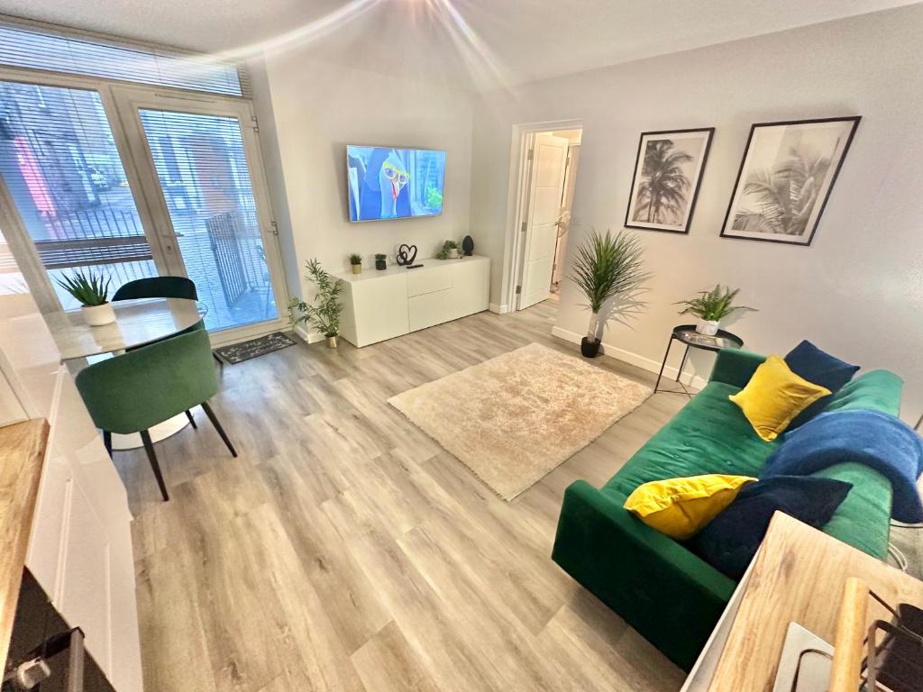 uma sala de estar com um sofá verde e uma mesa em Sleek Urban Getaway - With Parking em Bournemouth