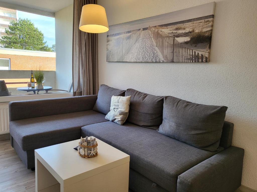 un soggiorno con divano e tavolo di Apartment 35 im Haus Villa Anna a Sankt Peter-Ording