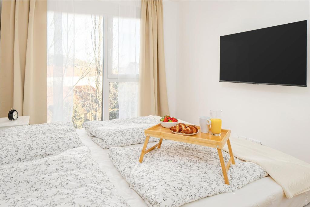 a room with two beds and a table with food on it at Oidahome - Apartment am Hauptbahnhof - contactless Self-Check-IN in Graz