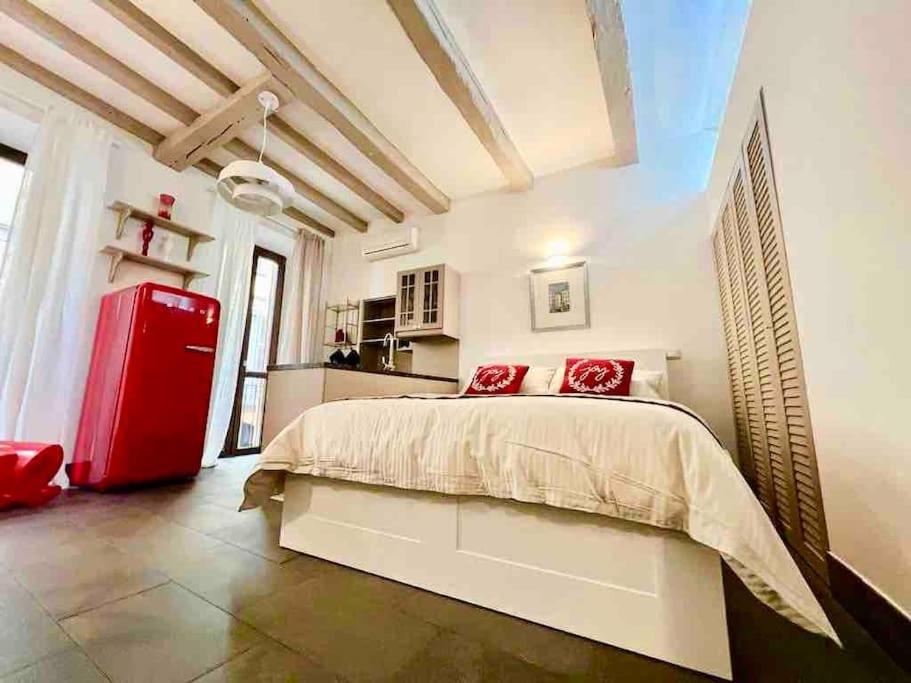 um quarto com uma cama e um frigorífico vermelho em Il Torchietto, incanto nel cuore di Milano em Milão