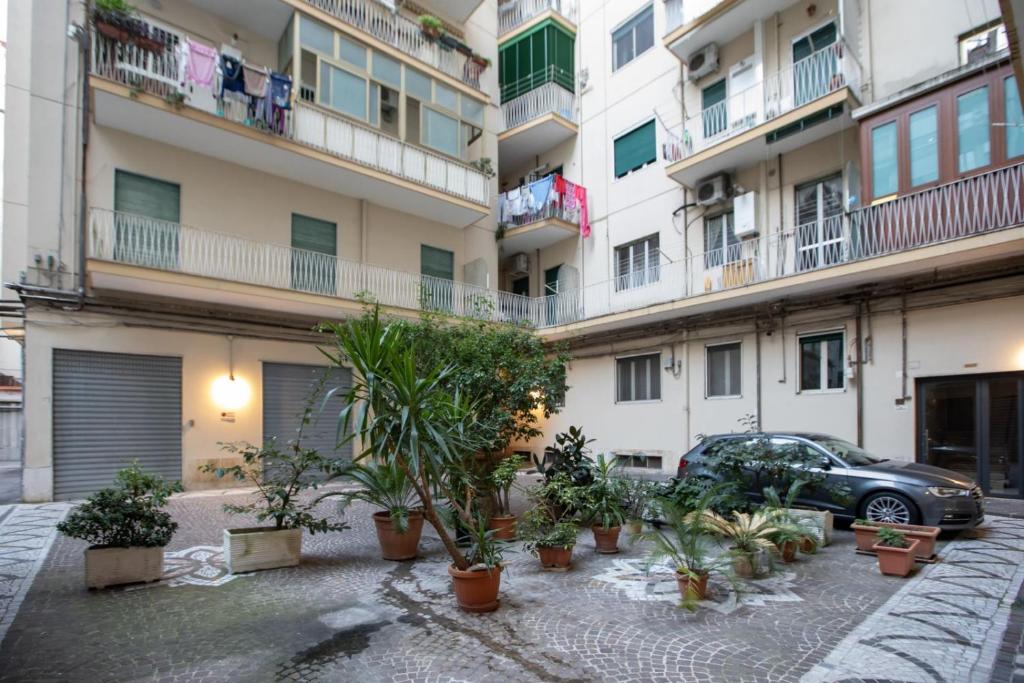 a car parked in front of a building with potted plants at B&B Zelia Napoli in Naples