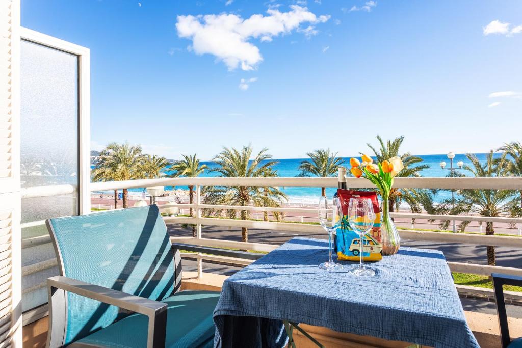 a table with a blue table cloth and flowers on a balcony at BAMBOO PLAGE AP4220 by Riviera Holiday Homes in Nice
