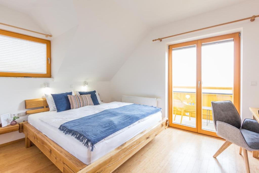 - une chambre avec un grand lit et un balcon dans l'établissement Vilaraj, à Maribor