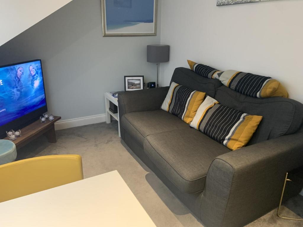 a living room with a couch and a flat screen tv at Lovely one bedroom apartment in Llandudno