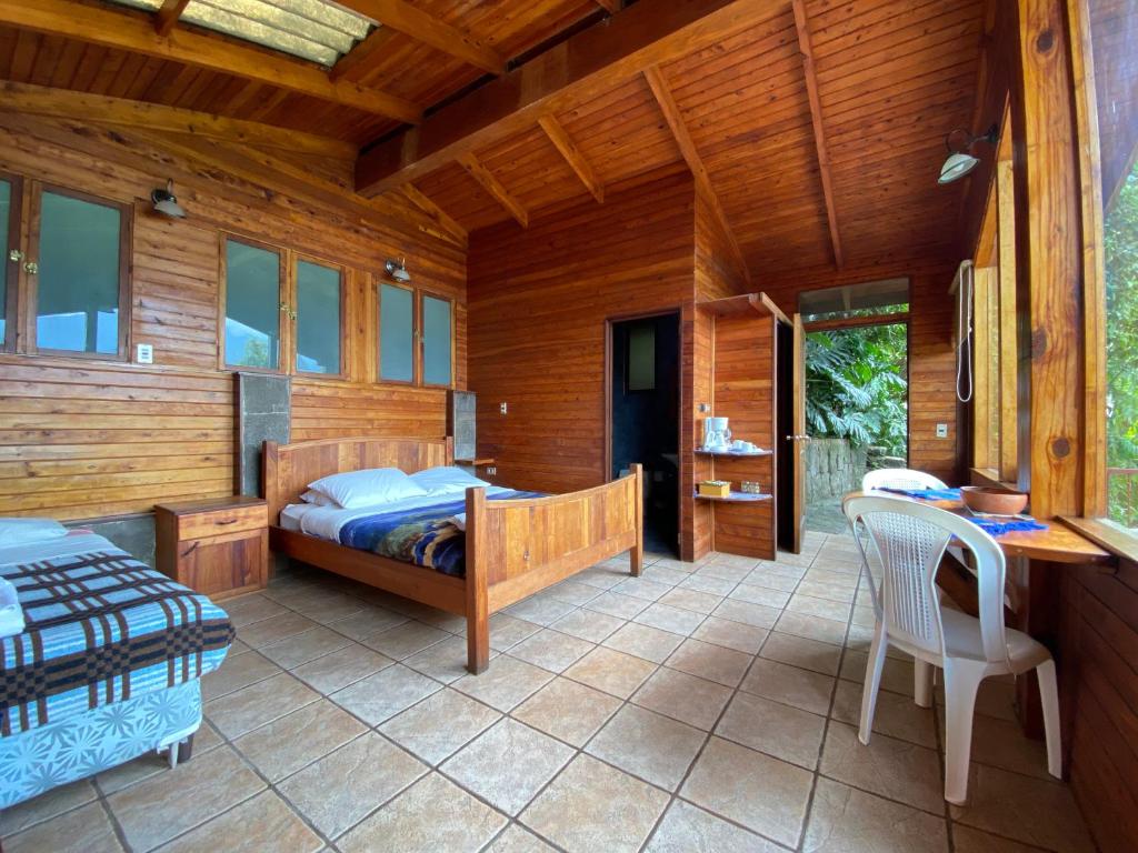 a bedroom with a bed and a table and chairs at Lakefront Chalet in San Juan La Laguna