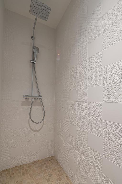 a shower with a shower head in a bathroom at Les Cotonnades Lorient in Lorient