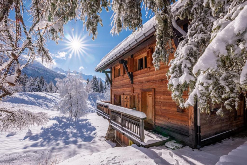a log cabin covered in snow in a forest at Spacious family chalet with balcony and garden in Chamonix