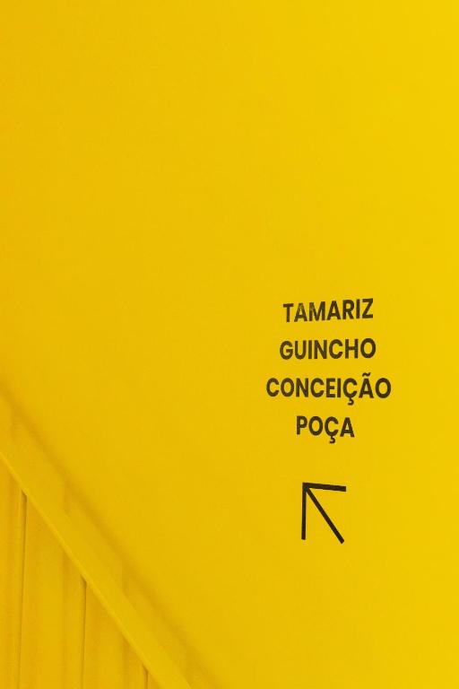 a yellow wall with some writings on it at Surf & Sea Suites in Parede