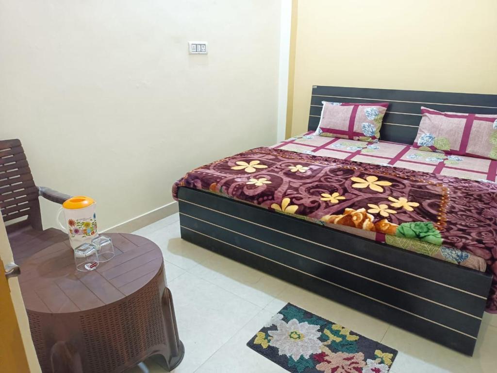 a bedroom with a large bed and a table at Om Home Stay in Ayodhya