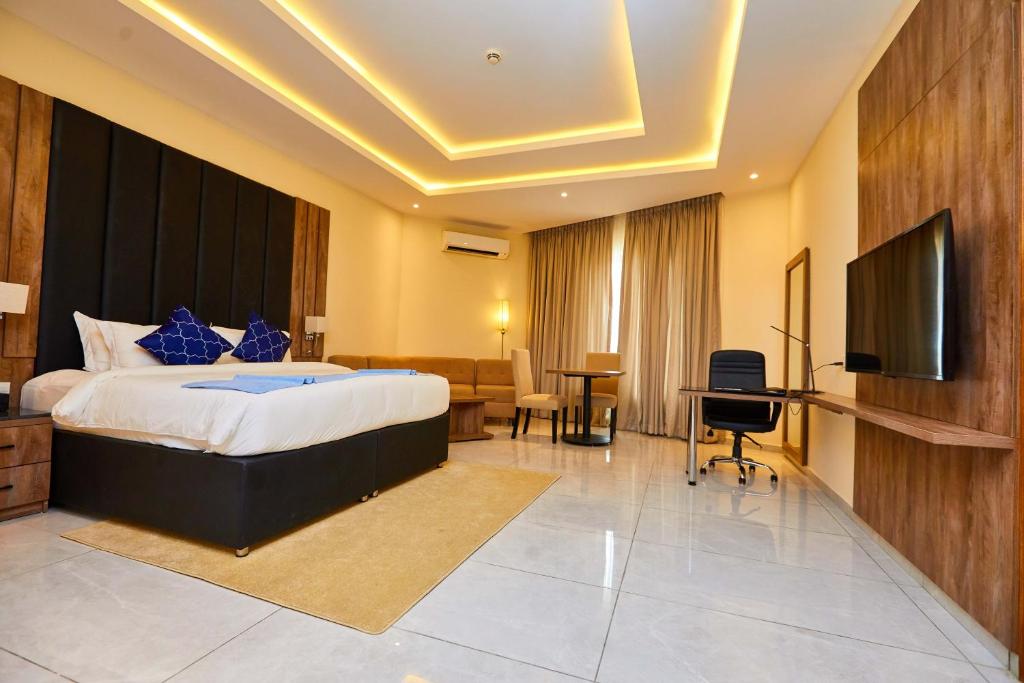 a hotel room with a bed and a flat screen tv at Vintano Hotel in Lekki