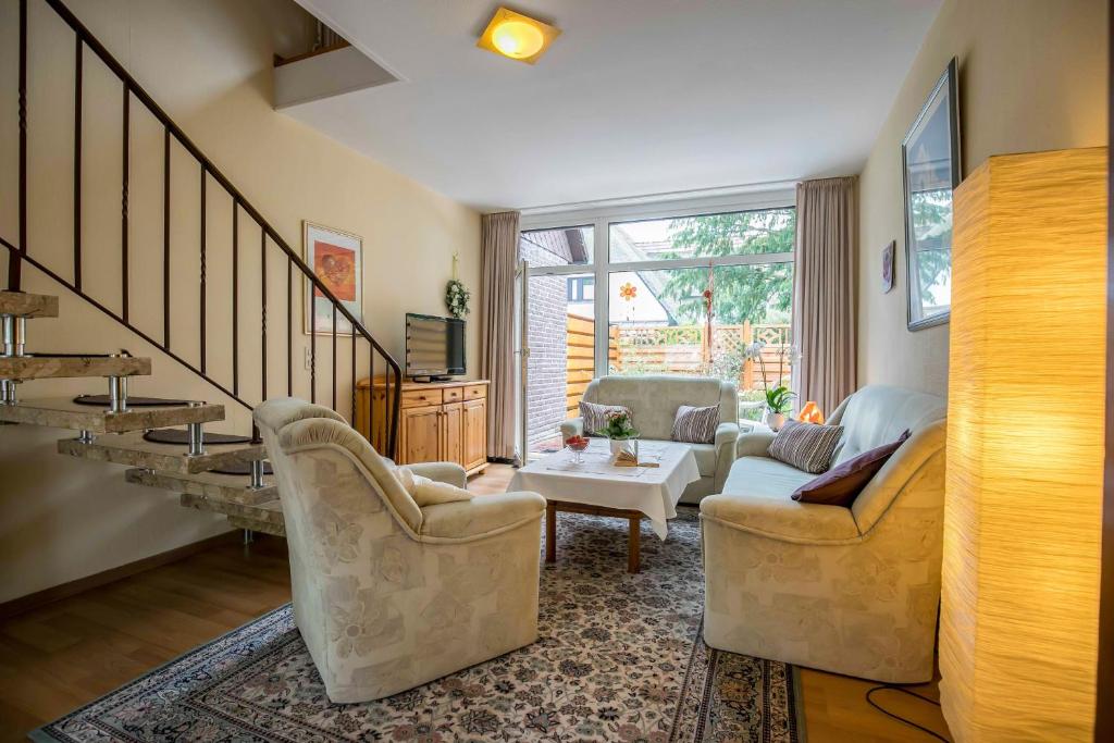 a living room with two chairs and a table at Ferienhaus an der Baeke D in Bad Zwischenahn