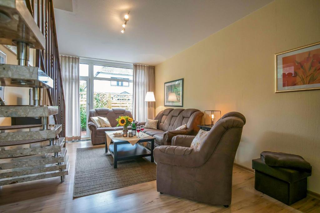 a living room with couches and a table at Ferienhaus an der Baeke A in Bad Zwischenahn