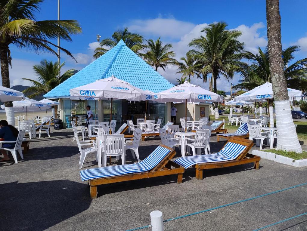 a group of chairs and umbrellas on a beach at Kitnets a 200 m da praia in Peruíbe